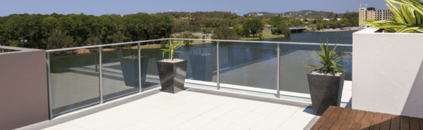 Choosing glass for your balustrade. An outdoor decking area with a tinted grey glass balustrade system.